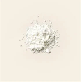 A small mound of white probiotic powder on a cream background, photographed by Promix as one of the ingredients in Debloat.
