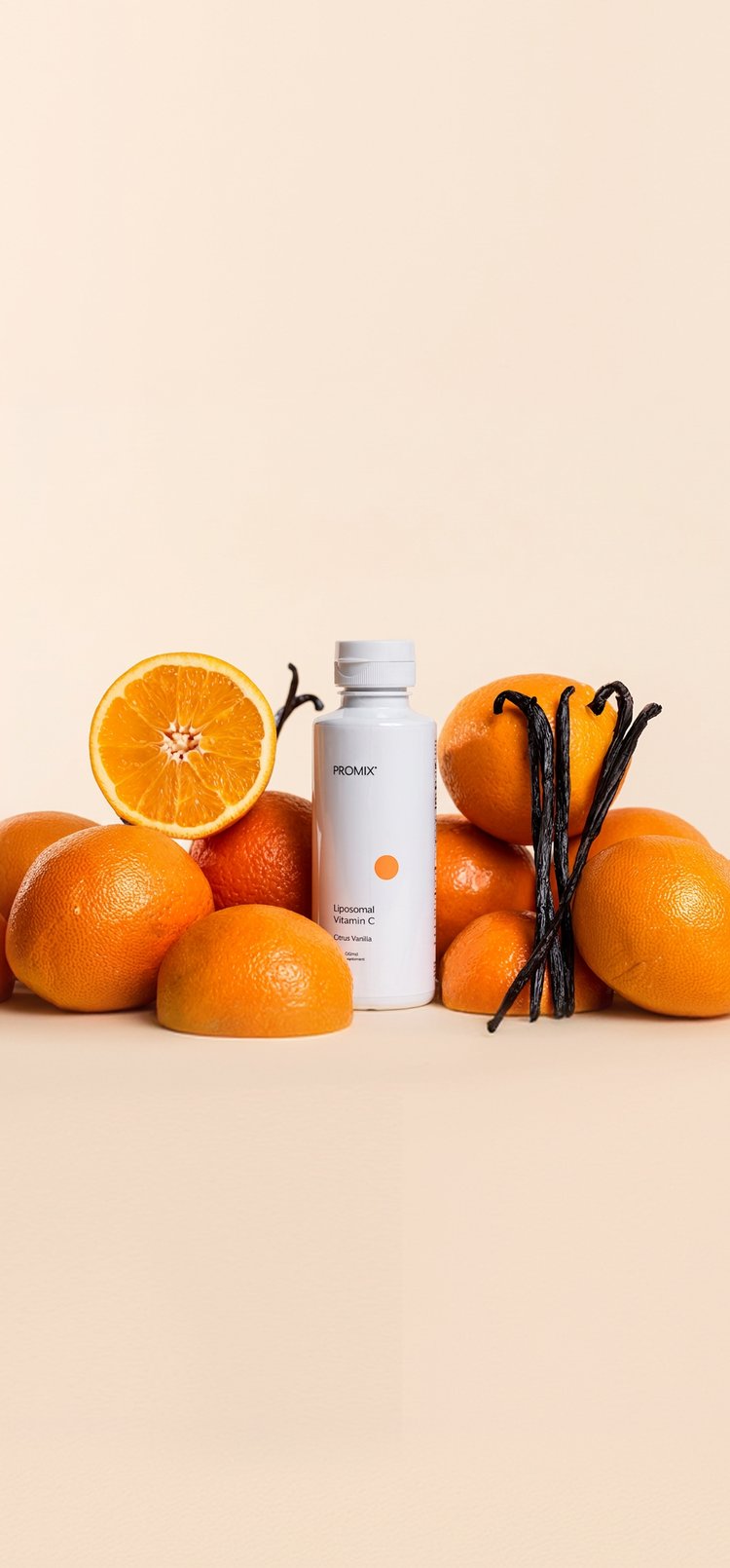 A bottle of Promix Liposomal Vitamin C among oranges and vanilla pods